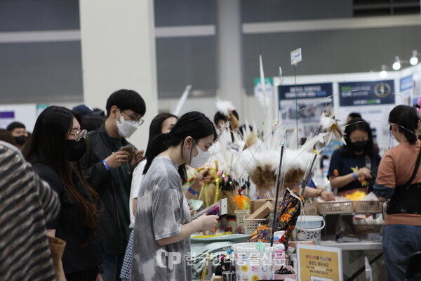 ▲ 관람객들이 행사에 참여한 업체의 제품을 유심히 보고 있다. 사진 = 문진학 기자